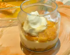 Step <p>Remoje brevemente la mitad de los bizcochos de soletilla en el zumo de naranja frío, lo justo para que se empapen sin romperse y vaya colocándolos en el fondo de una fuente rectangular o en envases individuales de cristal, Extienda la mitad de la mezcla de mascarpone sobre la base de bizcochos. Remoje los bizcochos restantes, colóquelos sobre la crema y cubra con el resto de la mezcla de mascarpone. Cubra con film transparente y refrigere durante 5 horas. </p> illustration