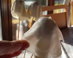 Step <p>Hidrate con agua caliente las hojas de arroz, cuando estén blandas colóquelas en cada fantasma, para darle mas cuerpo, luego dibuje o ponga los ojos que previamente se hacen con fondant negro. Decore la cupcake con azúcar glass y los fantasmitas.</p> illustration